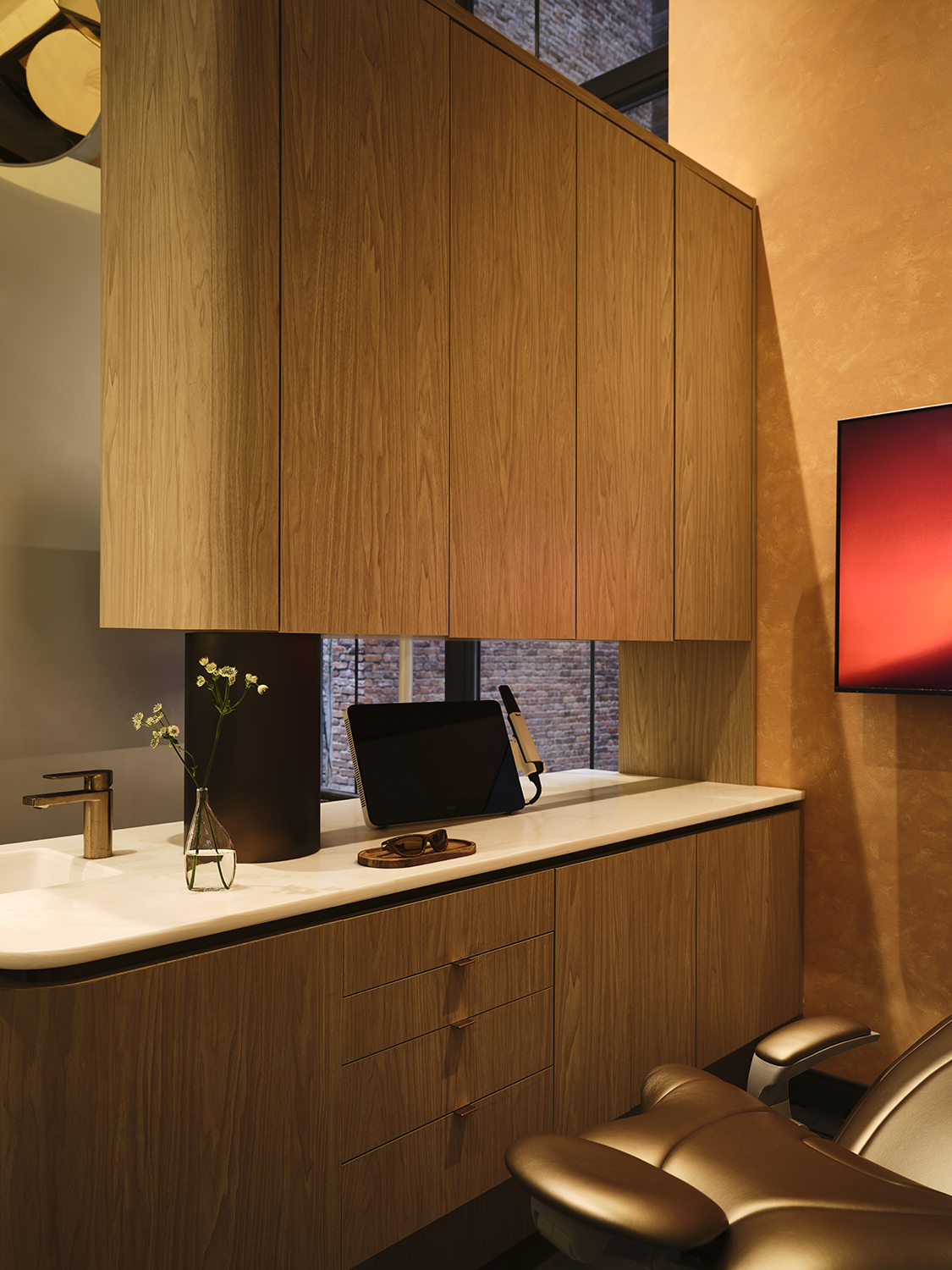 Smile House treatment room with white oak cabinetry, a stone counter, and a bronze dental chair