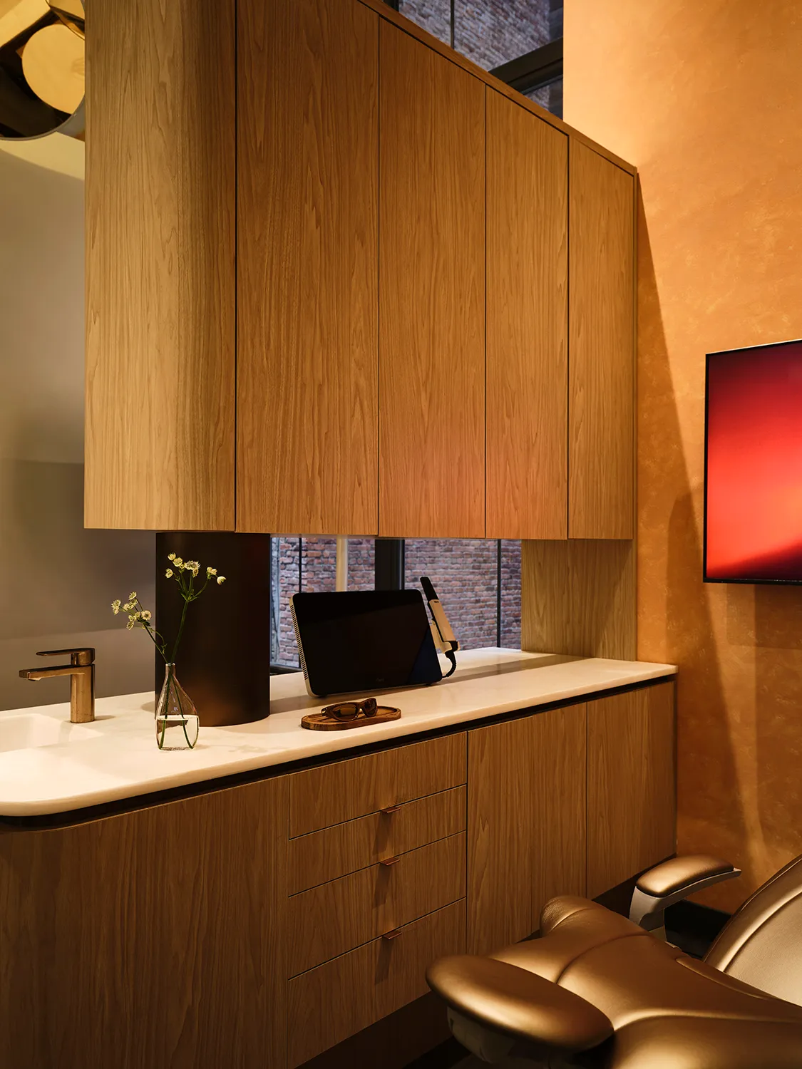 Smile House treatment room with white oak cabinetry, a stone counter, and a bronze dental chair