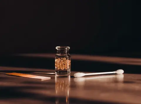 Illustration of a saliva test vial and pH strip