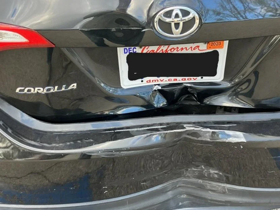 Daños en la parte trasera de un Toyota Corolla después de un accidente automovilístico en California, que muestran daños en el maletero y el parachoques abollados causados por una colisión trasera.