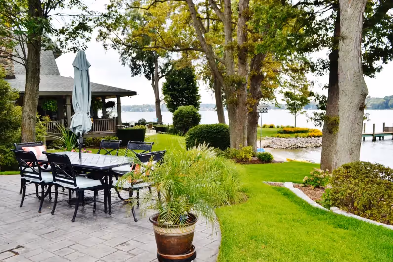 Lake house landscaping with patio and several trees