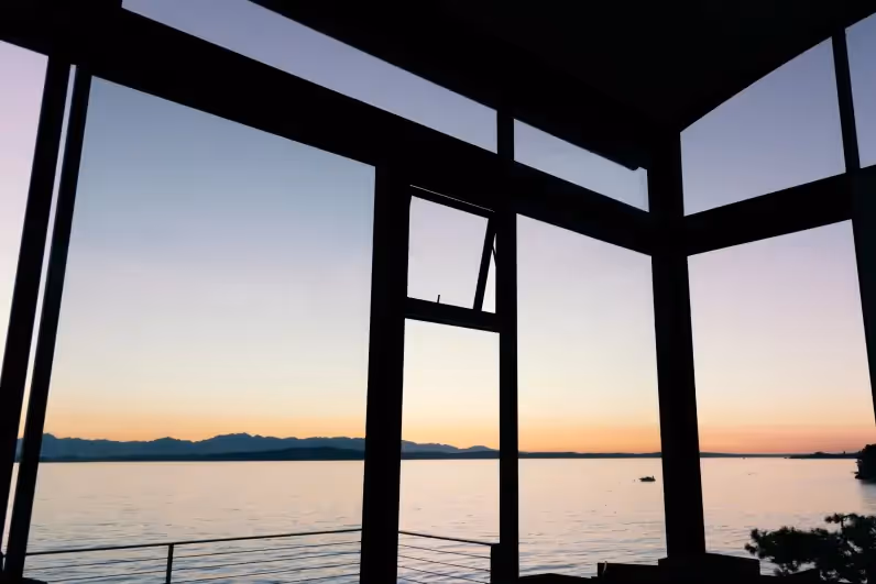 View from large floor to ceiling lake house windows overlooking the lake