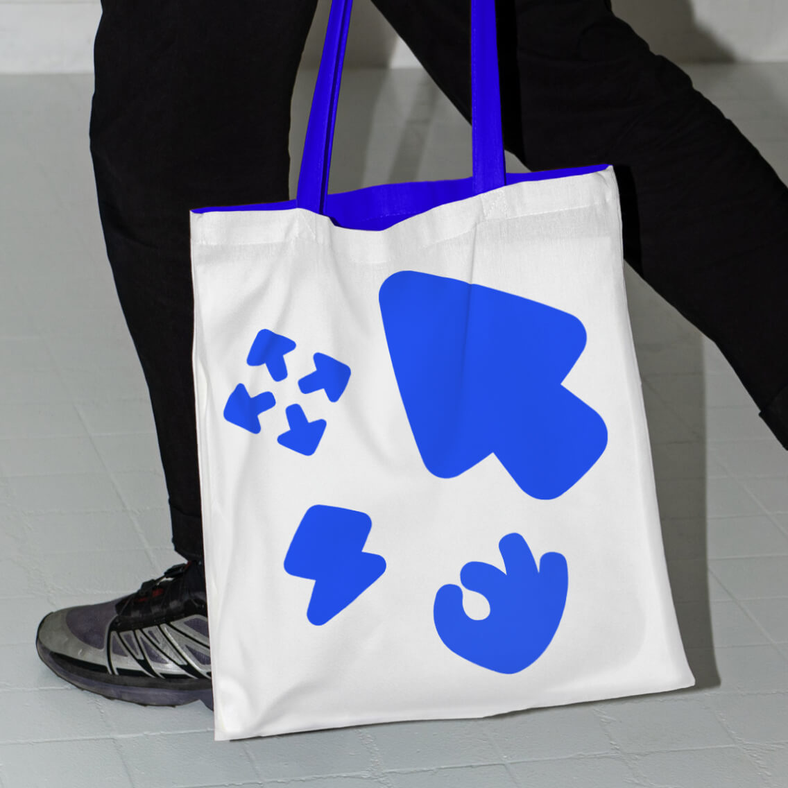 Bigger-branded canvas tote bag carrying the bold wordmark and bracket device