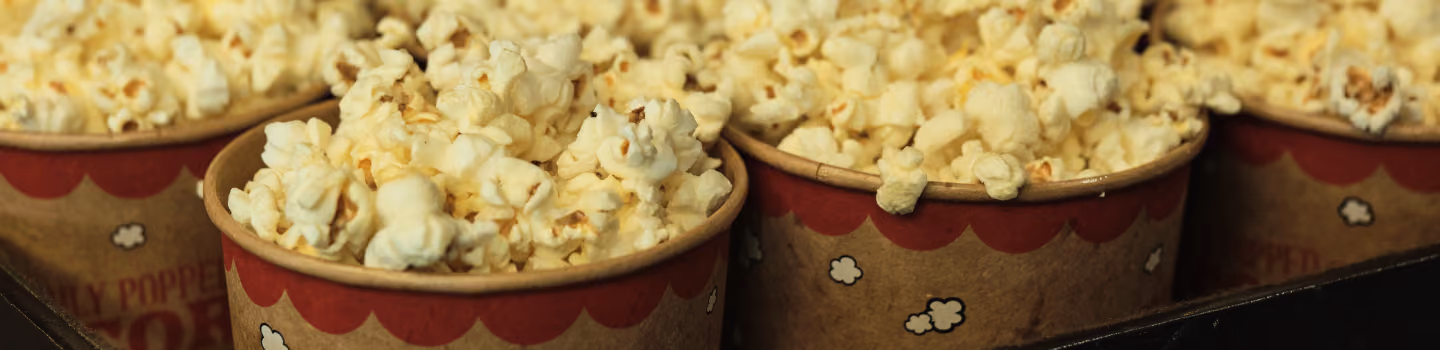 Several paper containers filled with freshly popped popcorn.