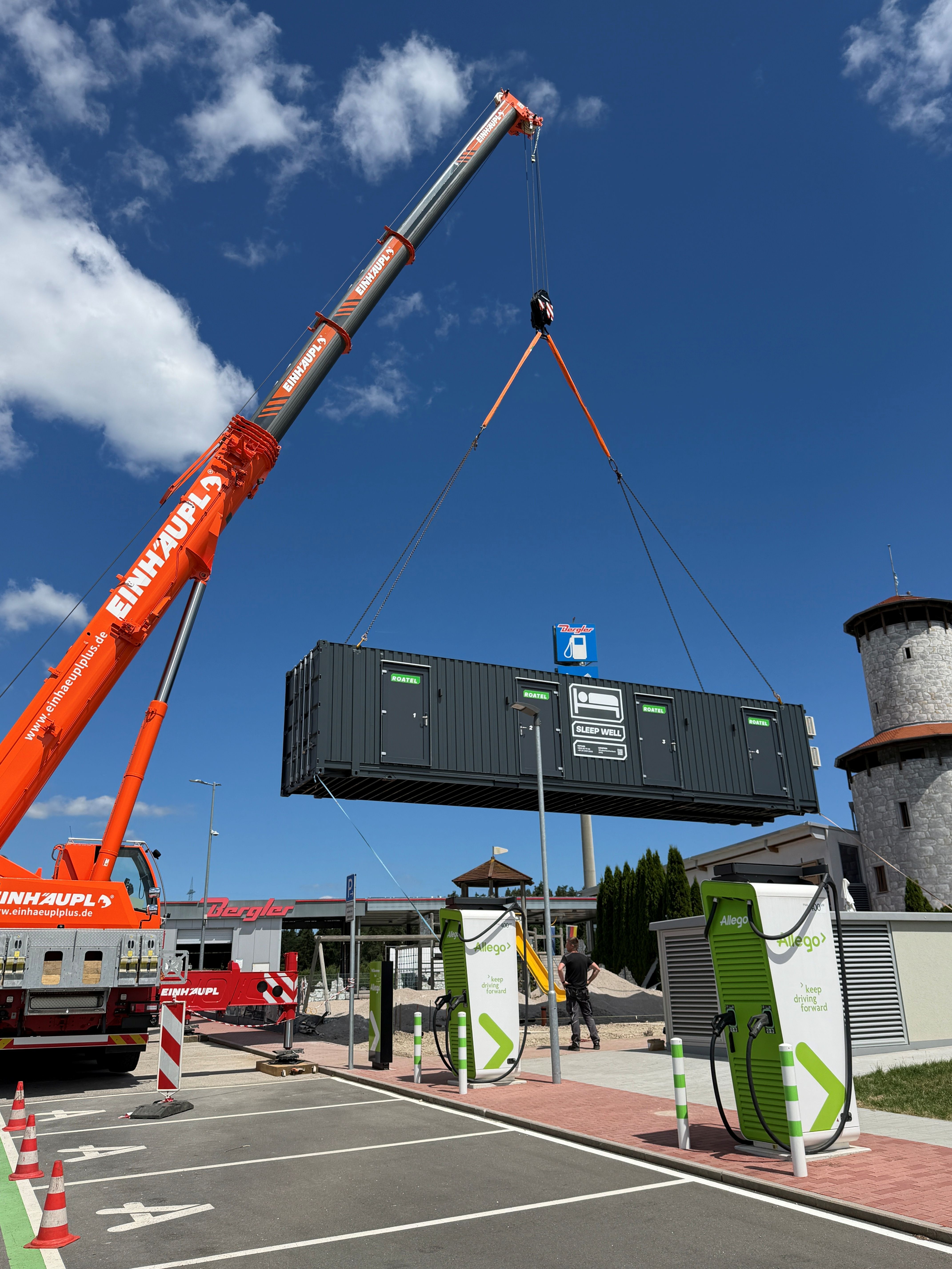 Vier Männer besprechen Dokumente vor einem großen gelben Container mit der Aufschrift Magnum.