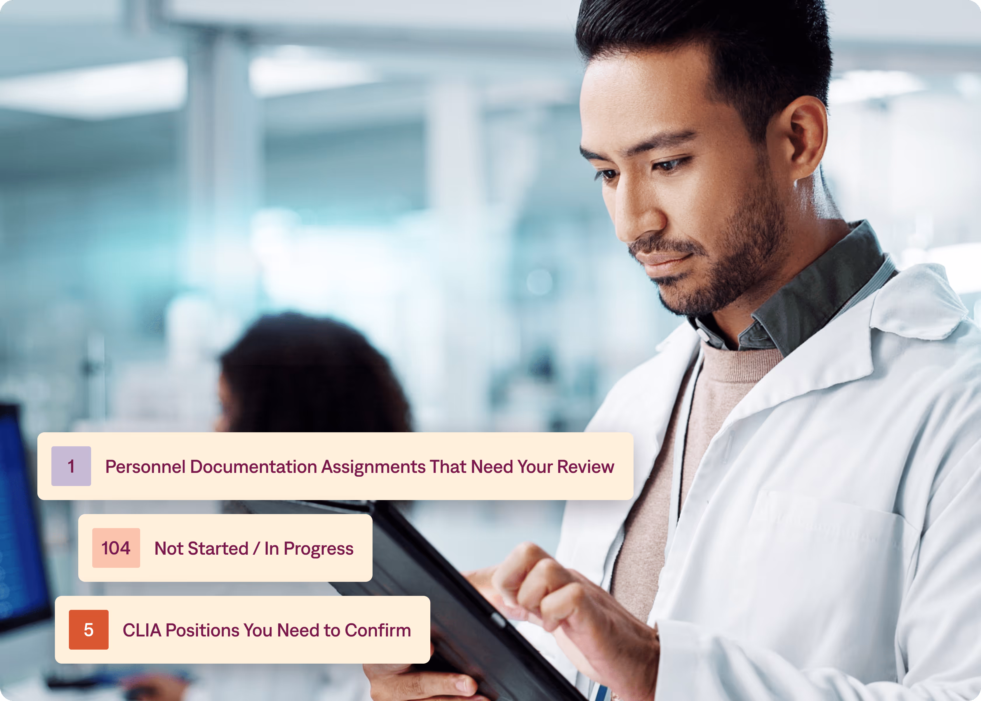A man in a lab coat is looking at a tablet