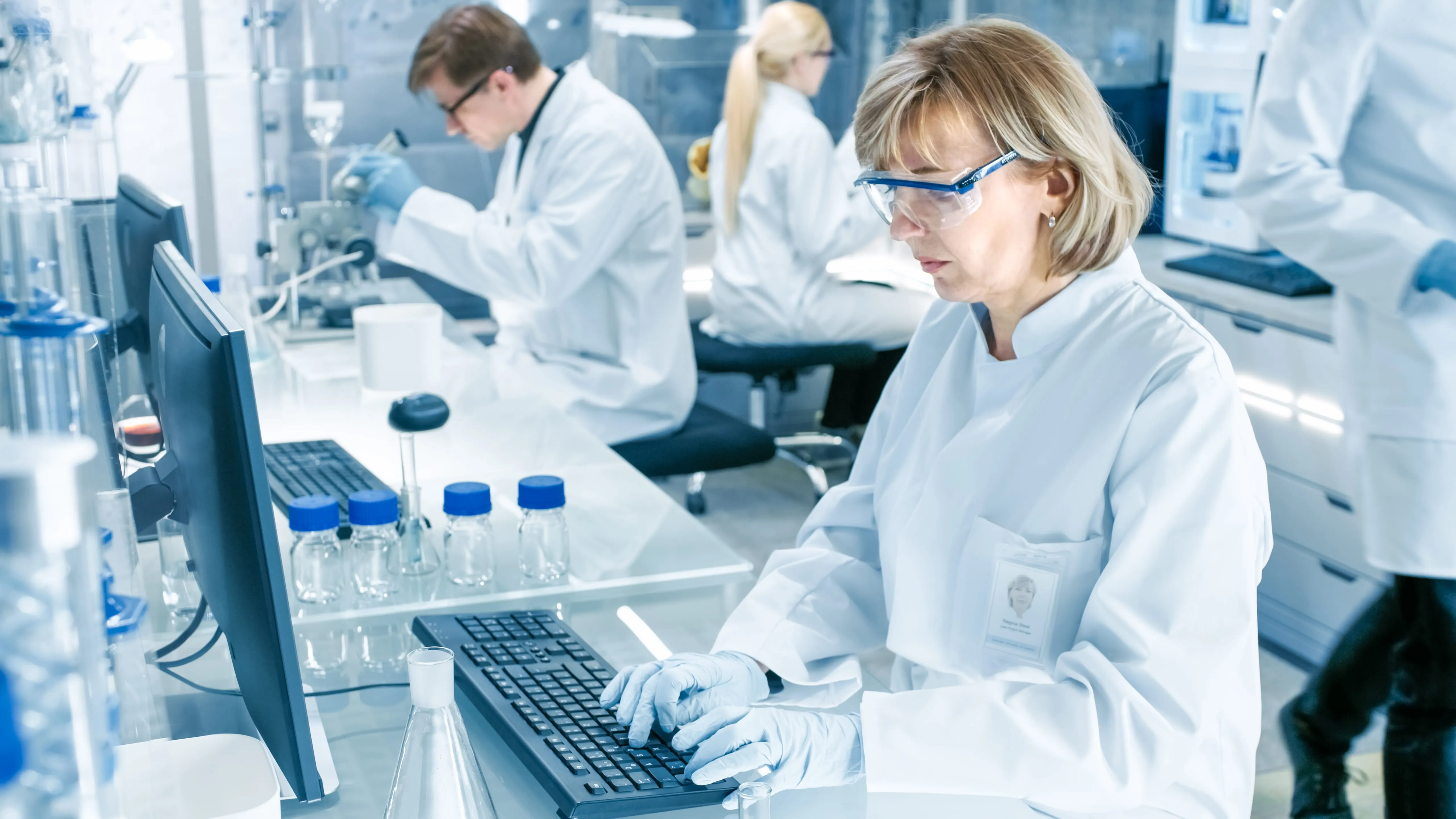 A female scientist is typing on a computer in a lab