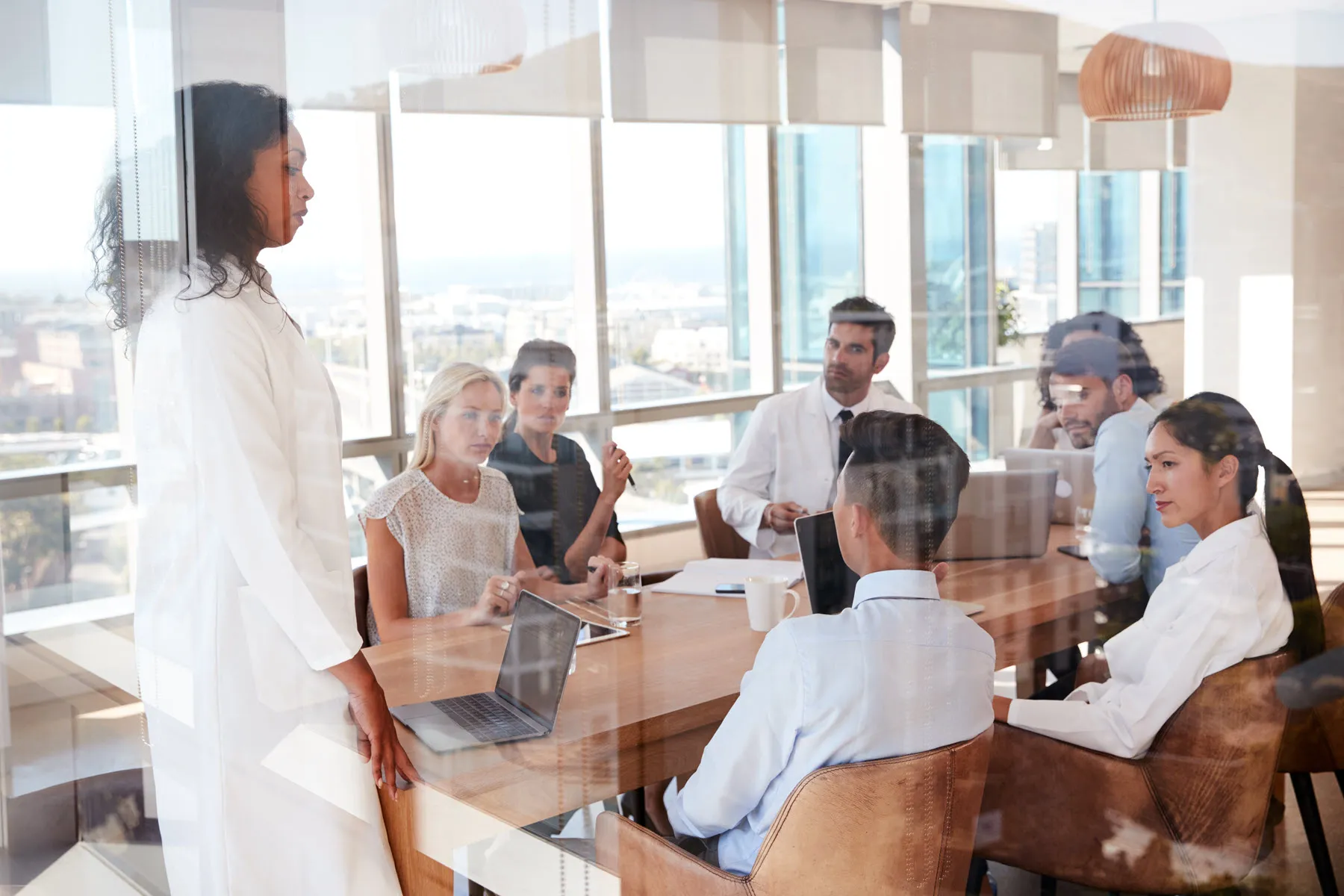 A woman stands in front of a group of people in a conference room