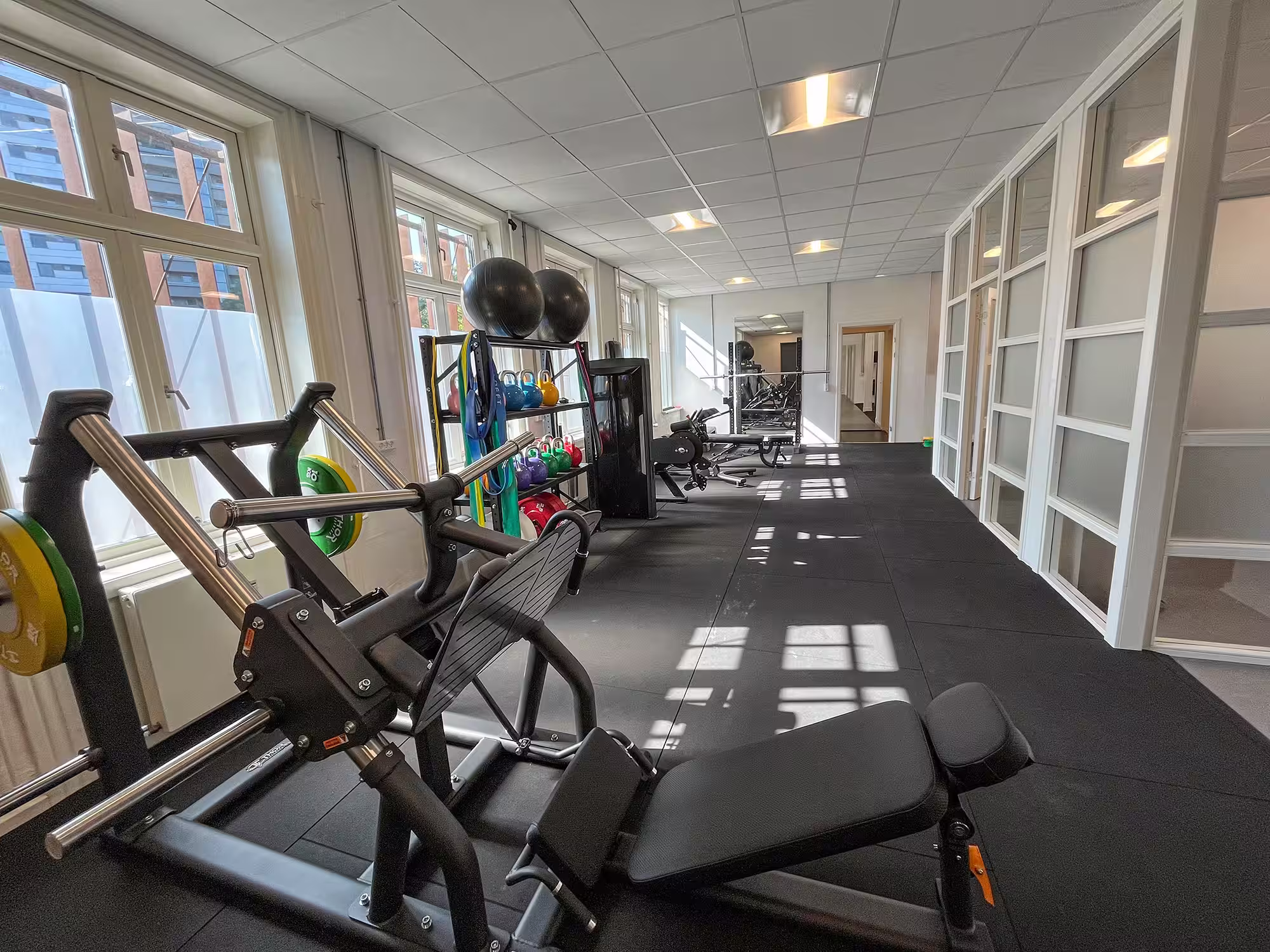 Styrketræningsområde hos LøberLab København med benpres, kettlebells og træningsudstyr