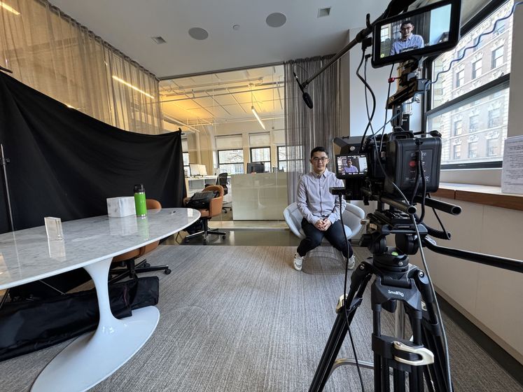 A Happy Productions interview setup with black backdrop and overhead boom in a city office