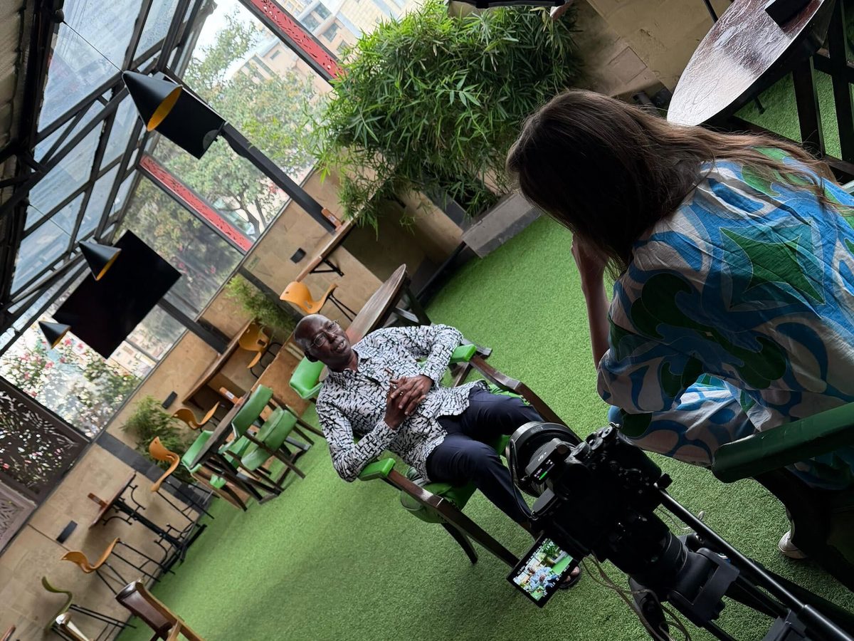 A Happy Productions interviewer directing a speaker on a rooftop terrace, two cameras rolling