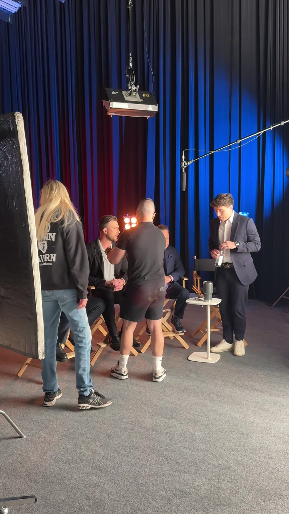 A Happy Productions crew preparing a lit studio set for a panel interview