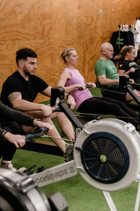 Gym members rowing