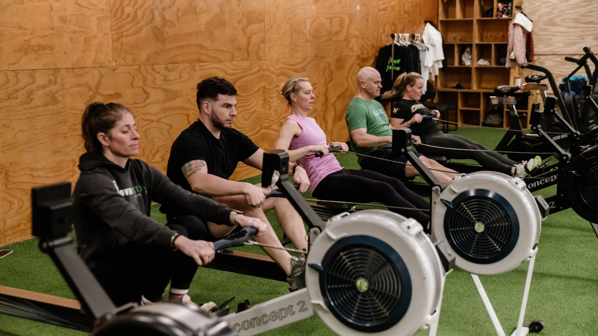 Gym members rowing