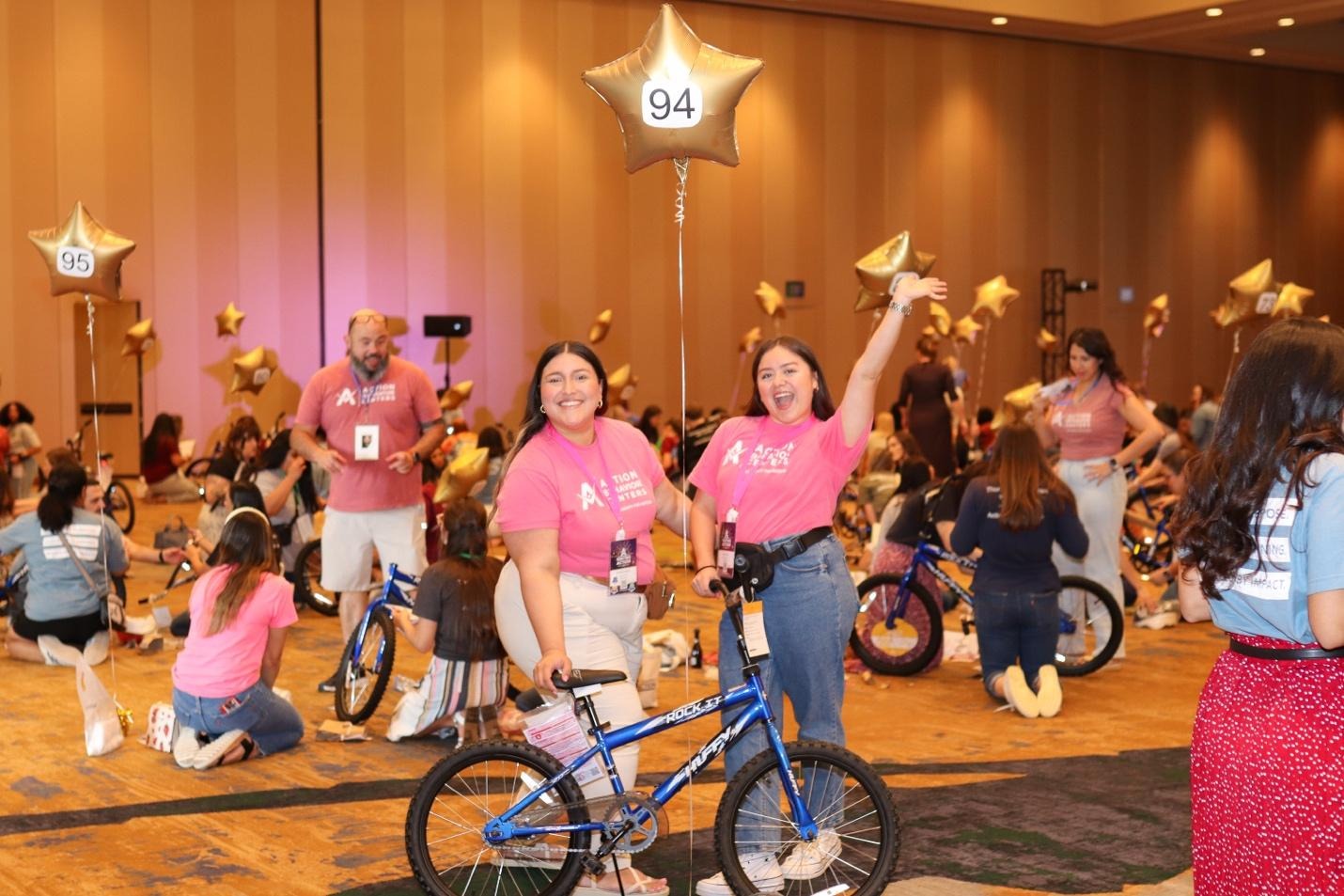 A group of people in a room with a bike and a balloonDescription automatically generated