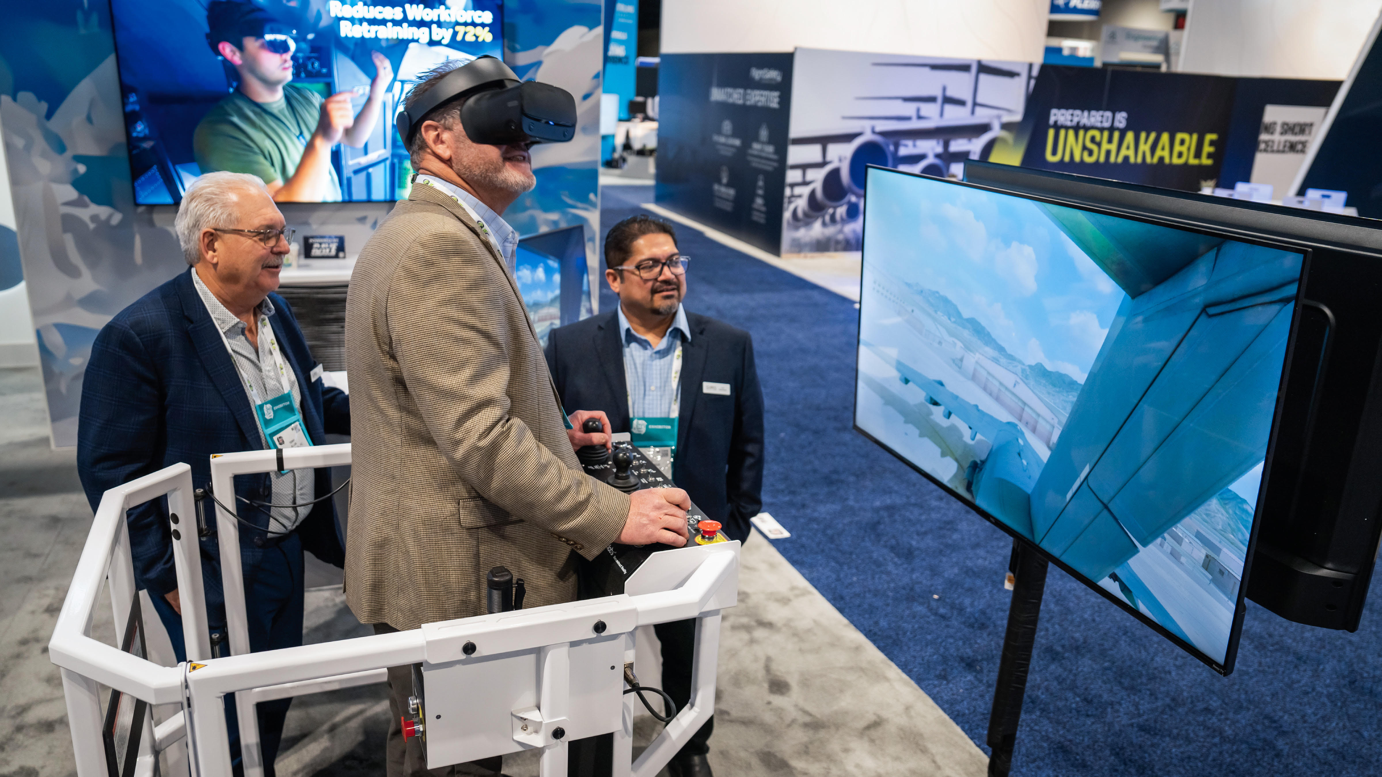 Attendees at a trade show booth around a training simulator.