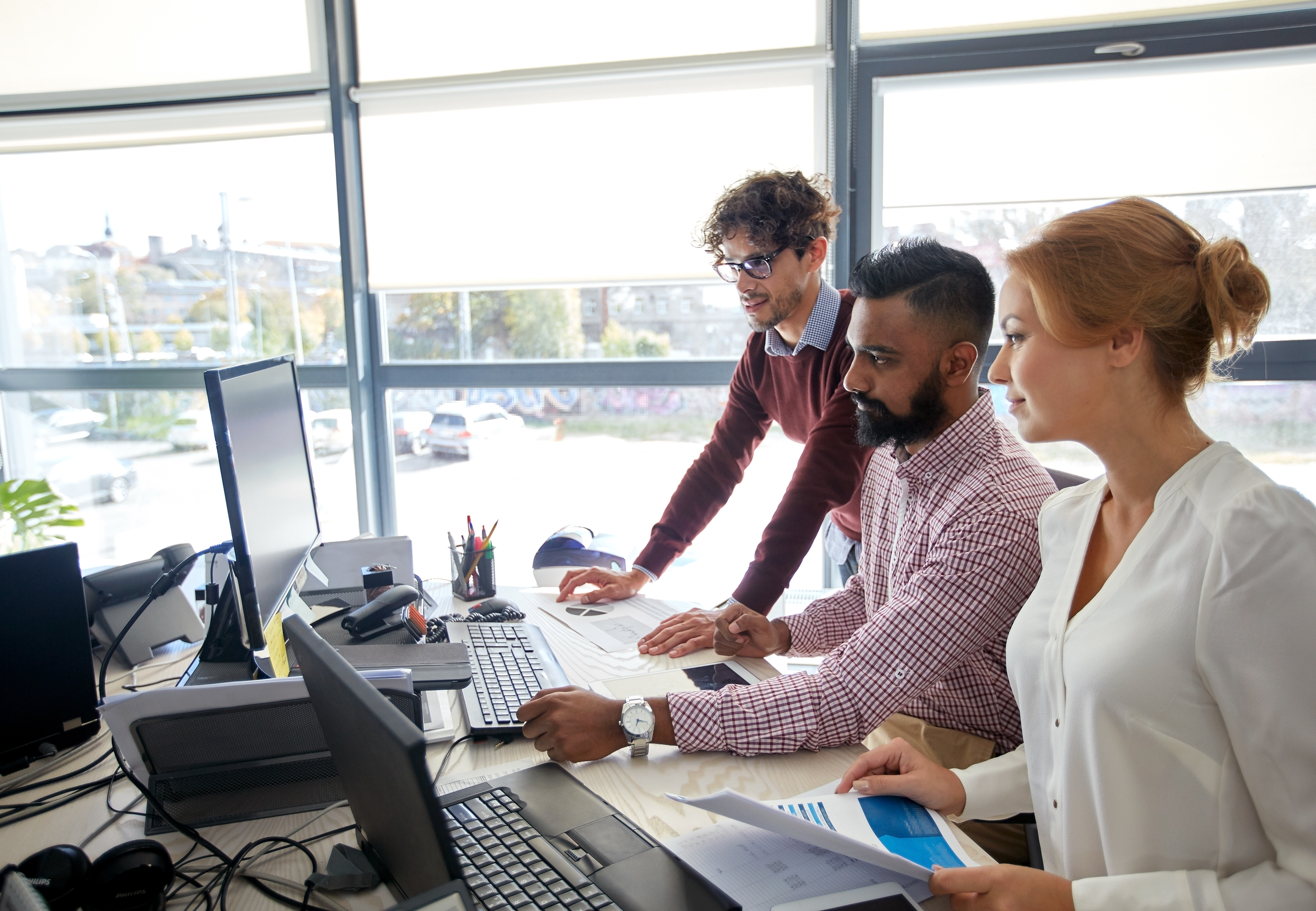 Business team analyzing charts and data in an office, planning automated content strategies. Understand what is programmatic SEO for content at scale.