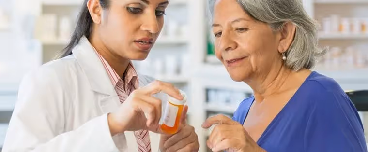 Old lady reading pill labels with the pharmacist