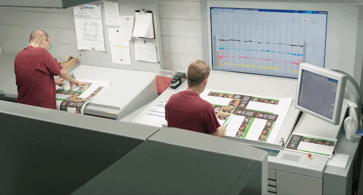 Proofreaders at Phoenix Litho manually examine press sheets for errors