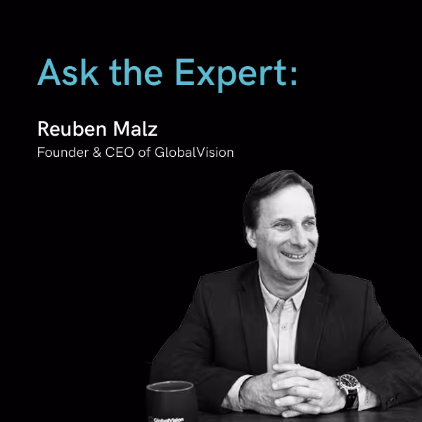 Reuben Malz, Founder and CEO of GlobalVision, smiling and sitting at a table with a coffee mug.