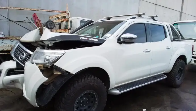 Damaged white Nissan ute in Melbourne awaiting scrap car removal and competitive car removal quote.