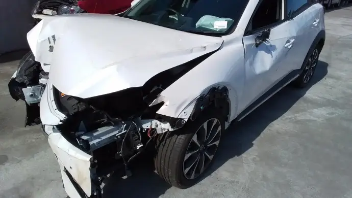 Non-running white hatchback with heavy front damage prepared for cash for cars and trade-in assessment in Melbourne.