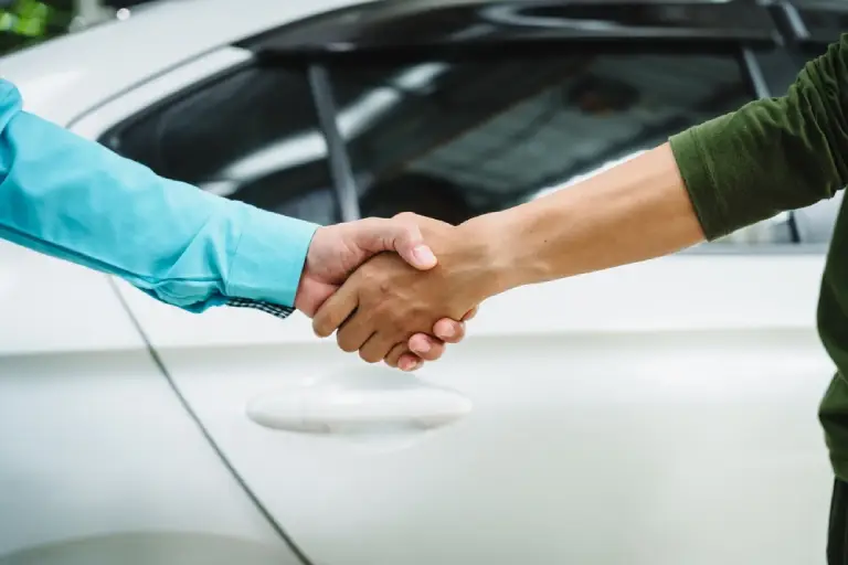 Car seller agent signs a car insurance agreement with salesman. The document outlines vehicle policy, premium, rental terms, with contract paper finalized using car insurance claim mobile phone.