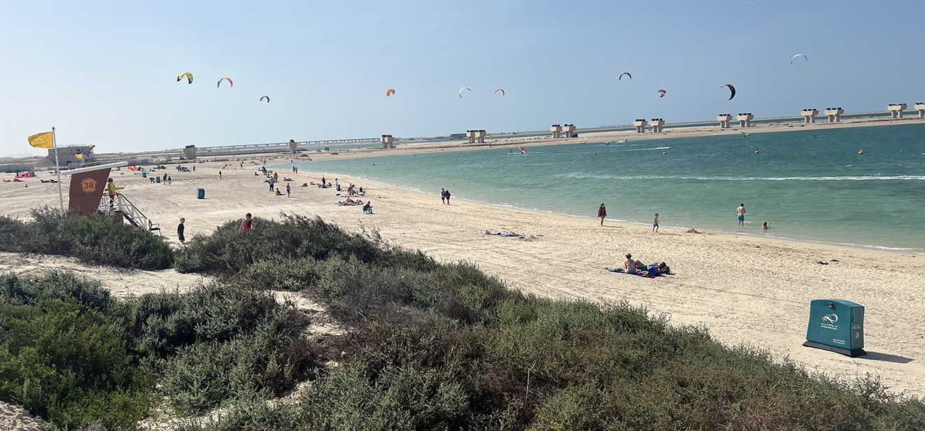 Mer et plage de Jebel Ali Public Beach avec des kitesurfs