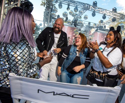 A guest and makeup artists dance during a marketing activation at Disney World.