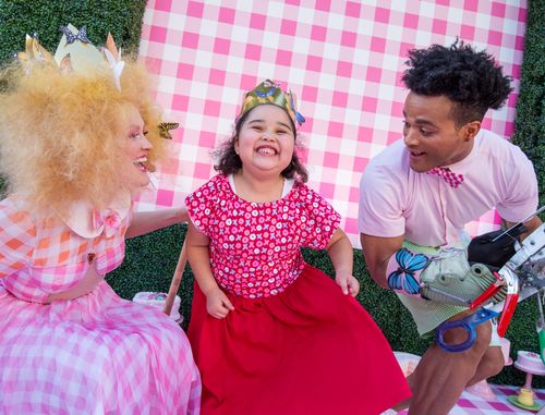 A young girl dances with characters at the Mad Hatterʻs tea party