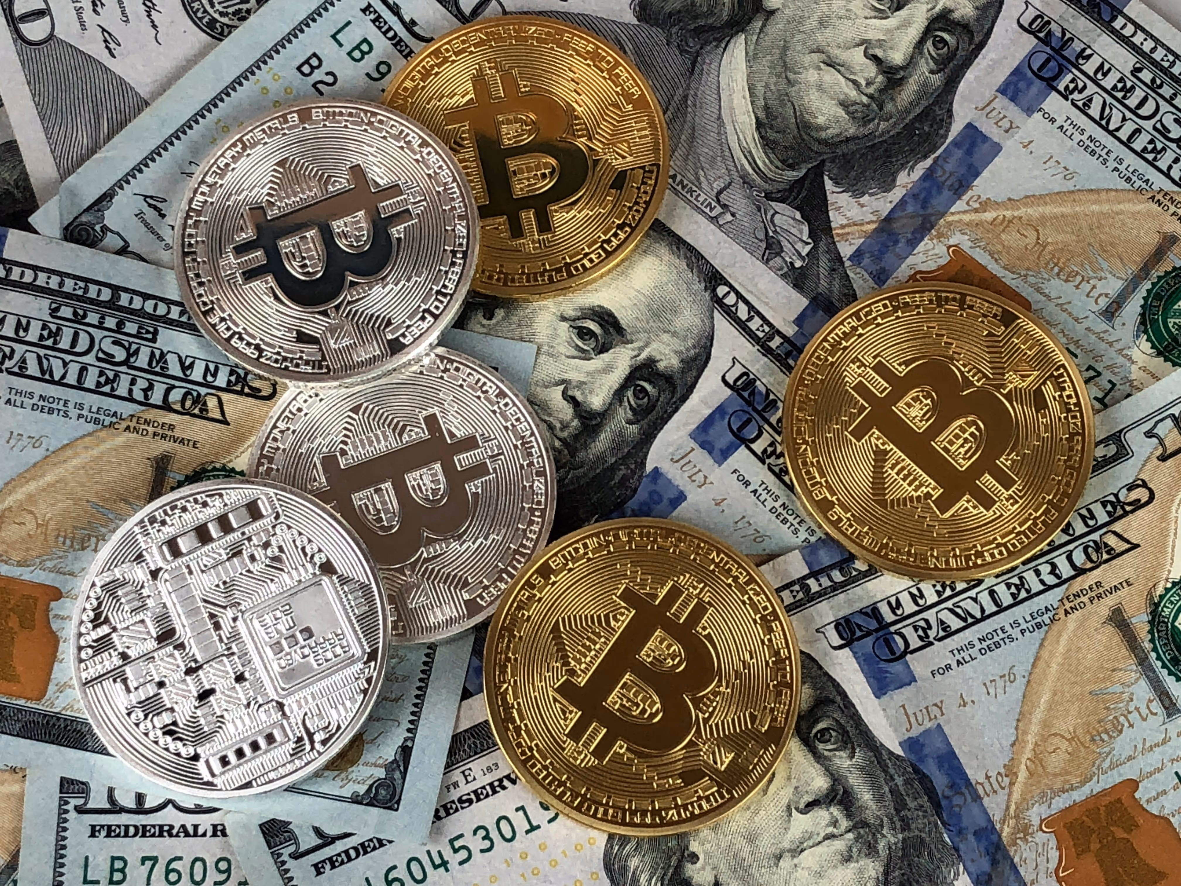 A pile of bitcoins sitting on top of a pile of money.