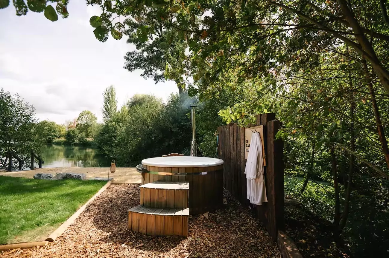 View of private hot tub on lake on sunny day.
