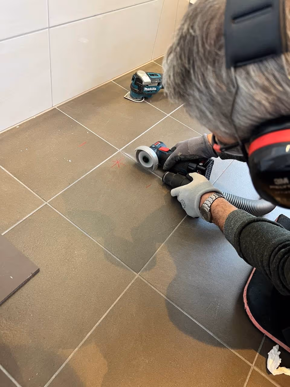 Bilde av reparatør som fikser membran på baderom.