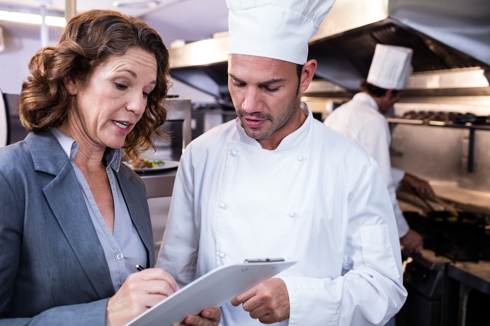 Female restaurant inspector talking to a male chef