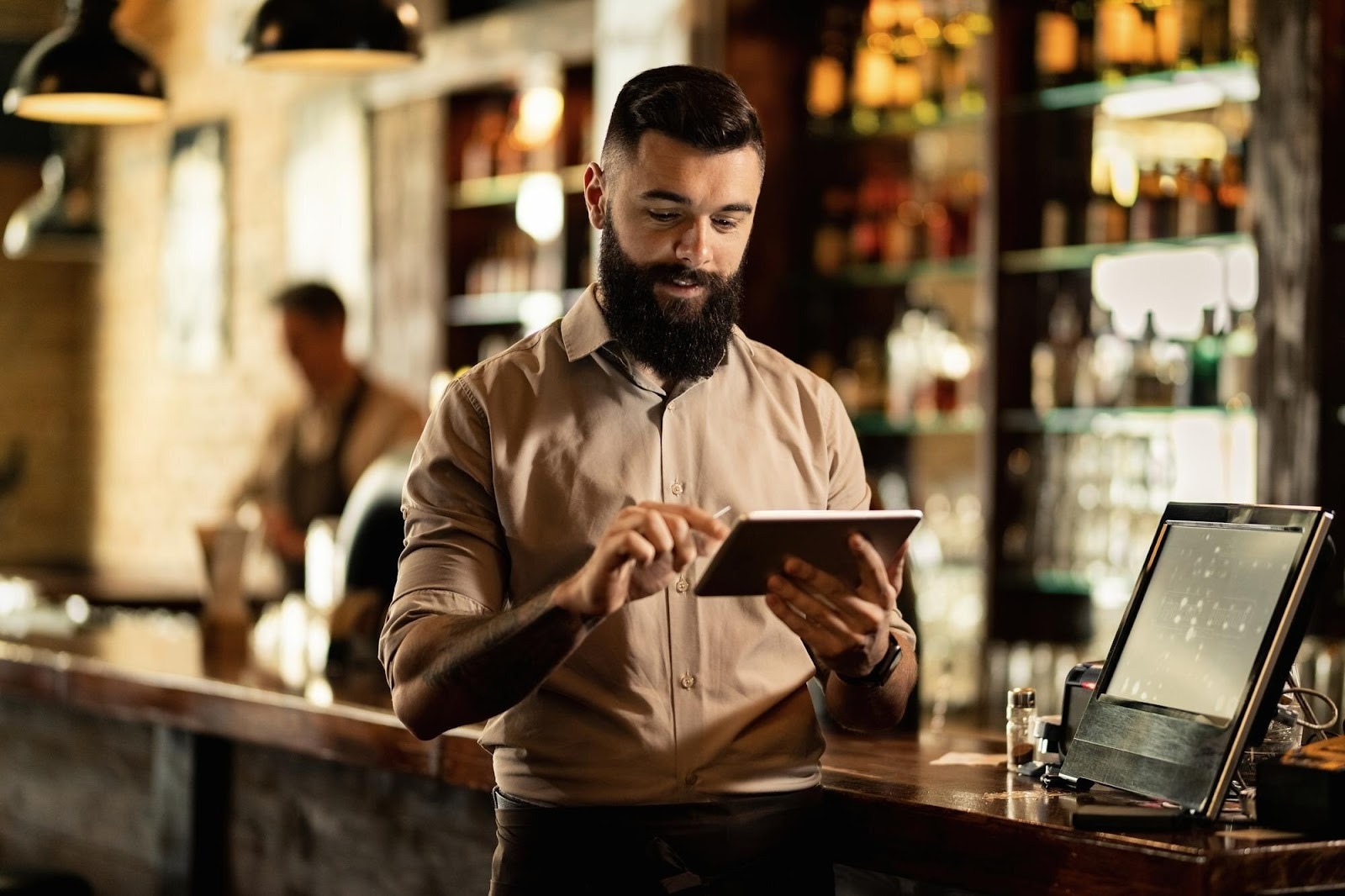 Male restaurant server using a work tablet