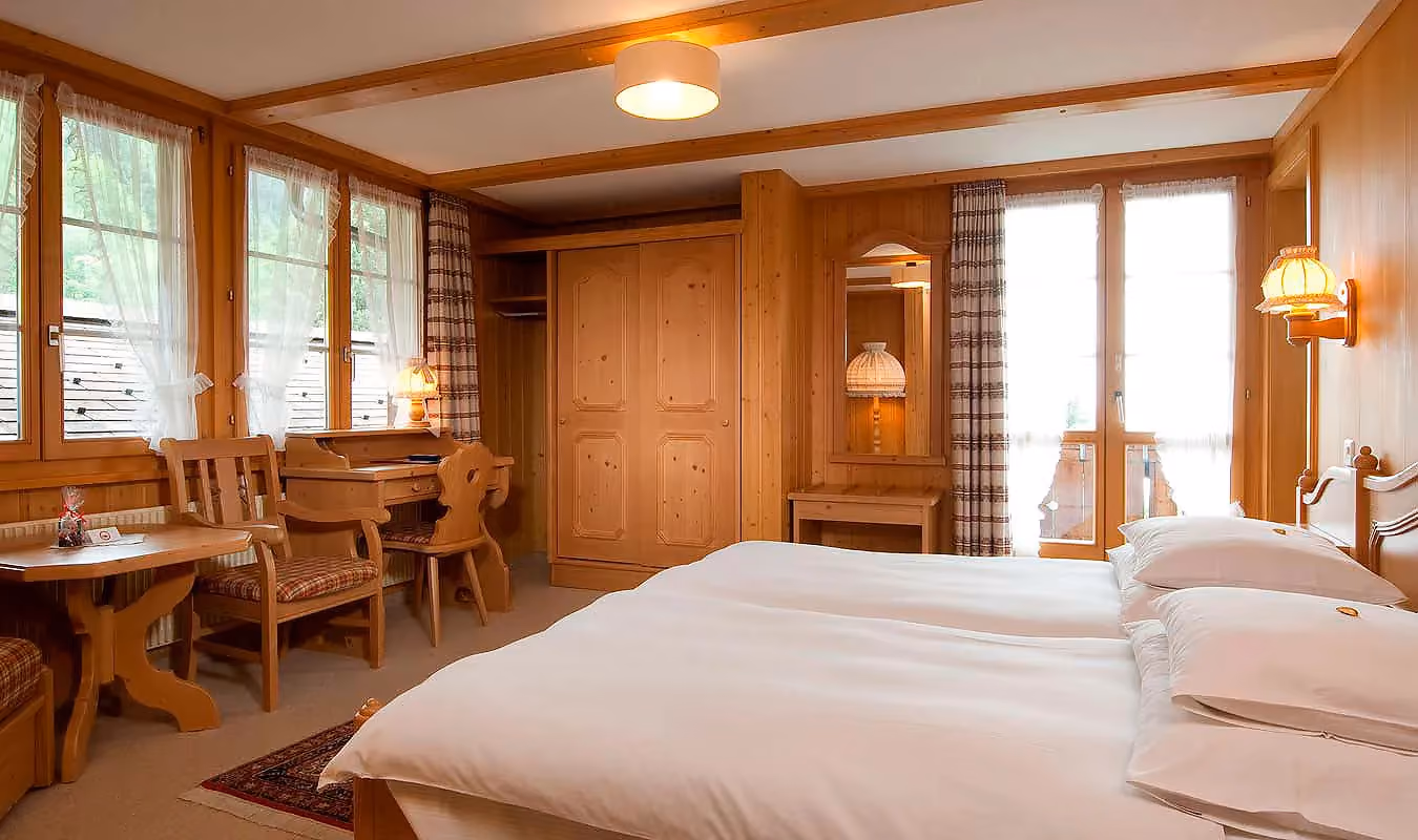 Doppelzimmer im Chalet Rossen, welches zum Hotel Alpenrose Wengen gehört. Es bietet einen Balkon mit Blick auf die Berge der Jungfrau Region.