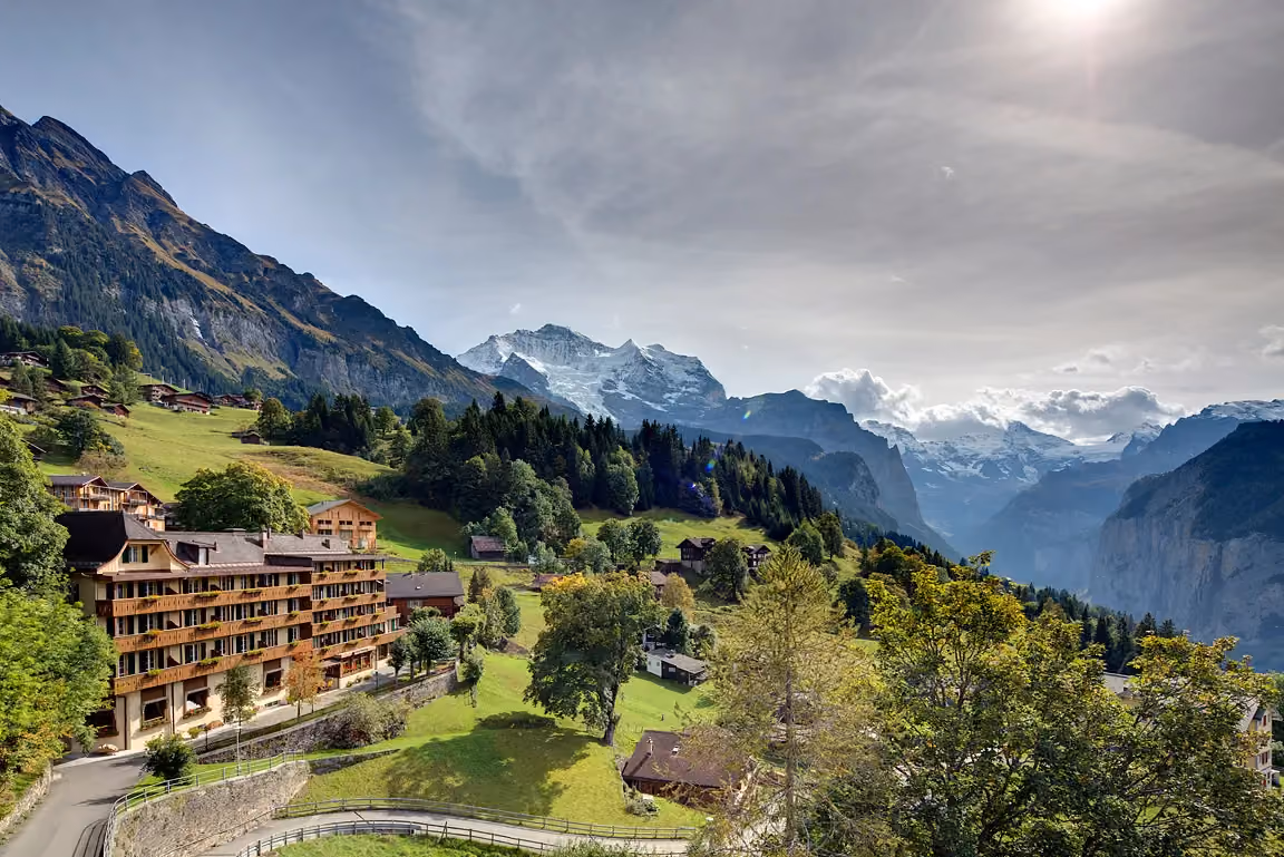 Blick auf das Hotel Alpenrose Wengen und das wildromantische Lauterbrunnental mit den umliegenden Berge der Jungfrau Region, Schweiz