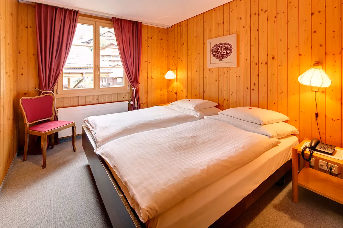 Das Schlafzimmer der Ferienwohnung 603 im Chalet Erika, welches zum Hotel Alpenrose Wengen gehört. Die Ferienwohnung bietet den schönsten Blick auf die Berge der Jungfrau Region.