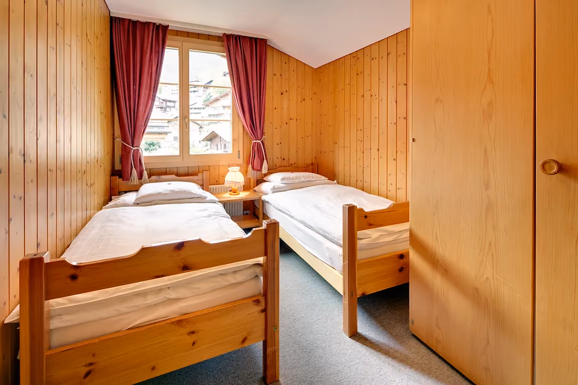 Das zweite Schlafzimmer der Ferienwohnung 603 im Chalet Erika, welche zum Hotel Alpenrose Wengen gehört. Die Ferienwohnung bietet den schönsten Blick auf die Berge der Jungfrau Region.