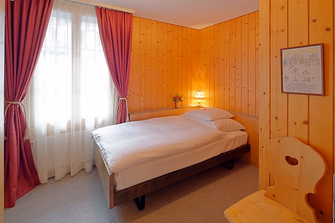 Das zweite Schlafzimmer in der Ferienwohnung 602 im Chalet Erika, welches zum Hotel Alpenrose Wengen gehört. Die Ferienwohung bietet den schönsten Blick auf die Berge der Jungfrau Region.