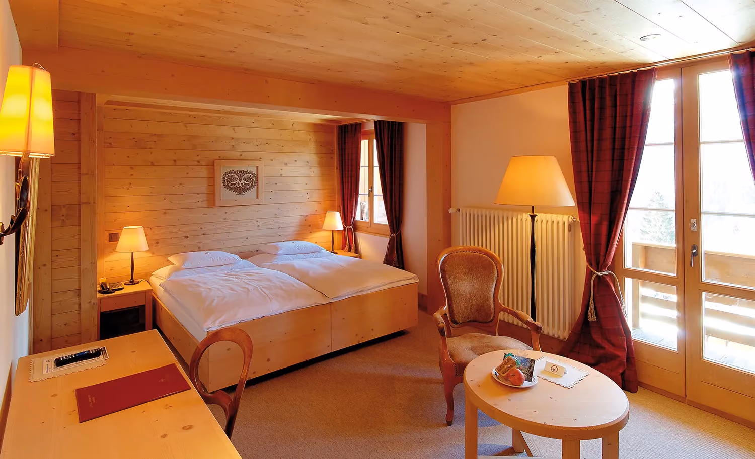 Das Superior Doppelzimmer mit Sitzecke und mit Bergblick vom Hotel Alpenrose Wengen. Diese Zimmer bieten einen wunderschönen Blick auf die Berge der Jungfrau Region.