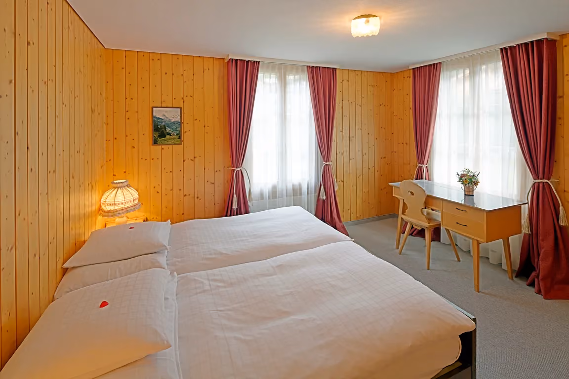 Das Schlafzimmer der Wohnung 602 im Chalet Erika. Das Chalet Erika gehört zum Hotel Alpenrose Wengen und bietet den schönsten Blick auf die Berge der Jungfrau Region.