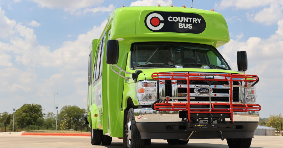 A bright green CARTS Country Bus parked under a blue sky, showcasing its new branded design and front-mounted bike rack.