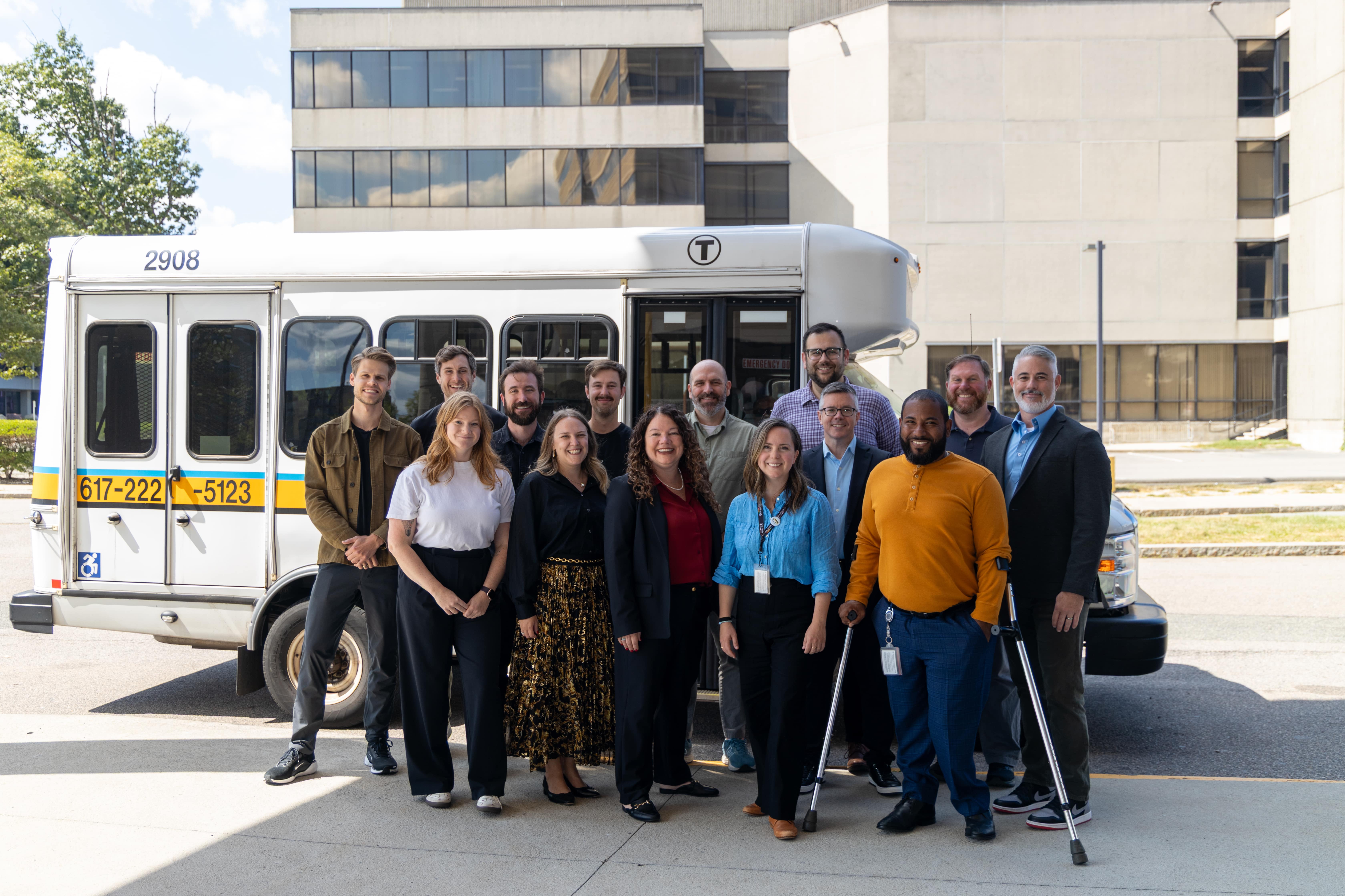 Spare and MBTA teams stand together in front of a paratransit vehicle, celebrating their partnership on modernizing ADA eligibility.