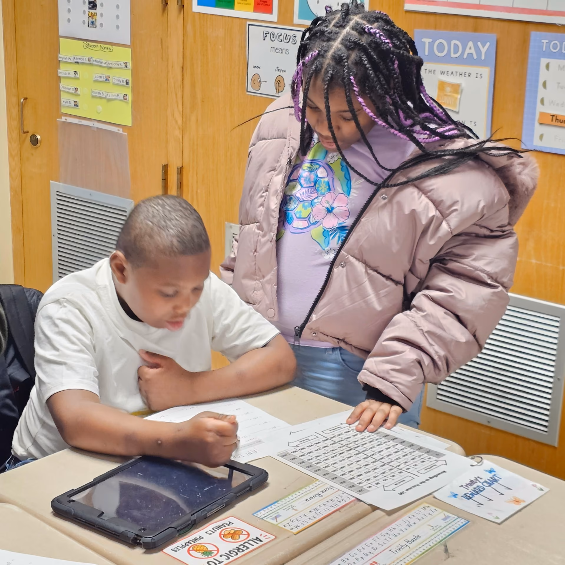 Two students collaborating on a worksheet at a classroom desk