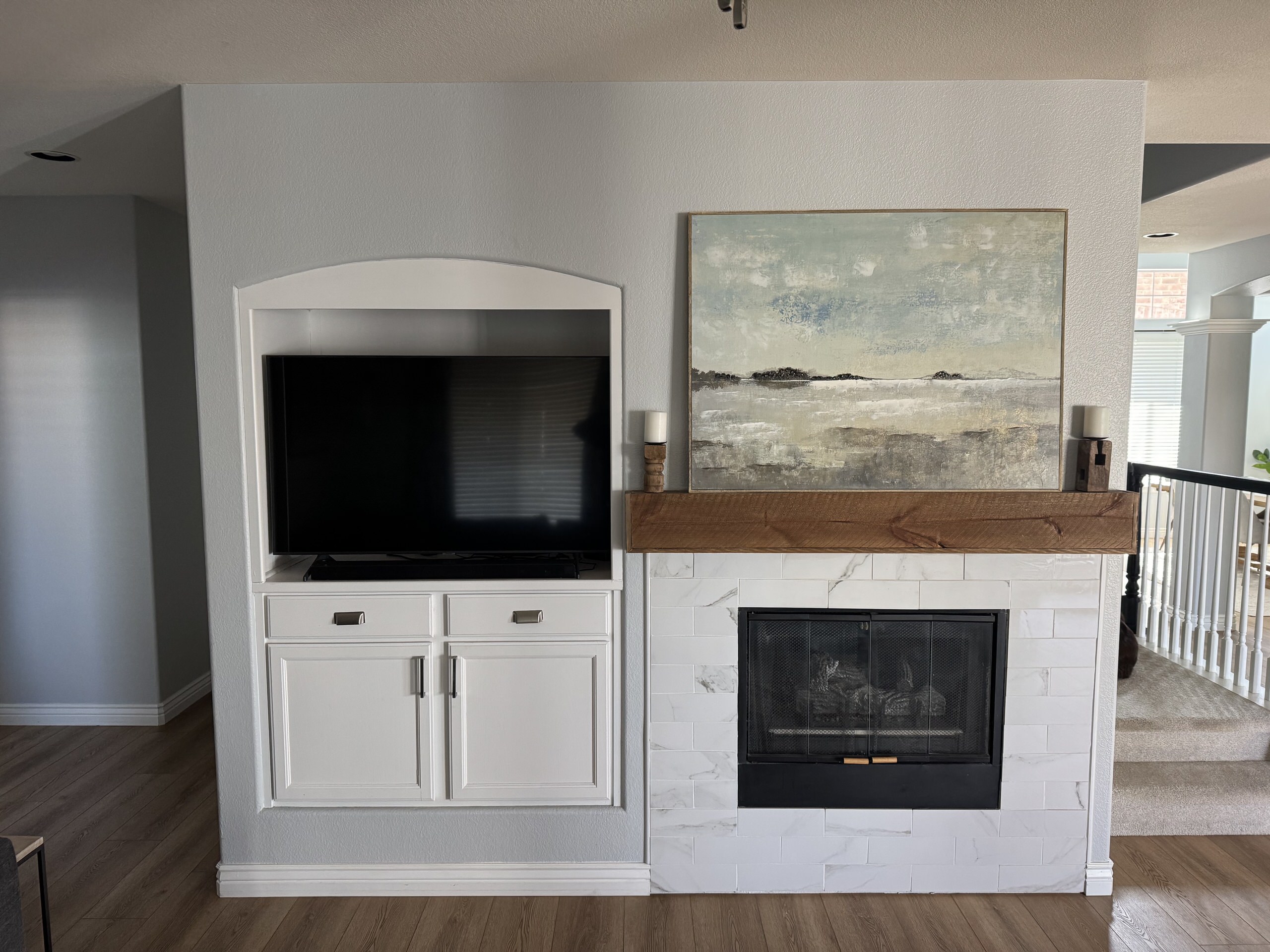 Wide "before" shot of an original 1990s fireplace layout in Highlands Ranch featuring a dated tile surround and an arched TV niche that lacked symmetry.