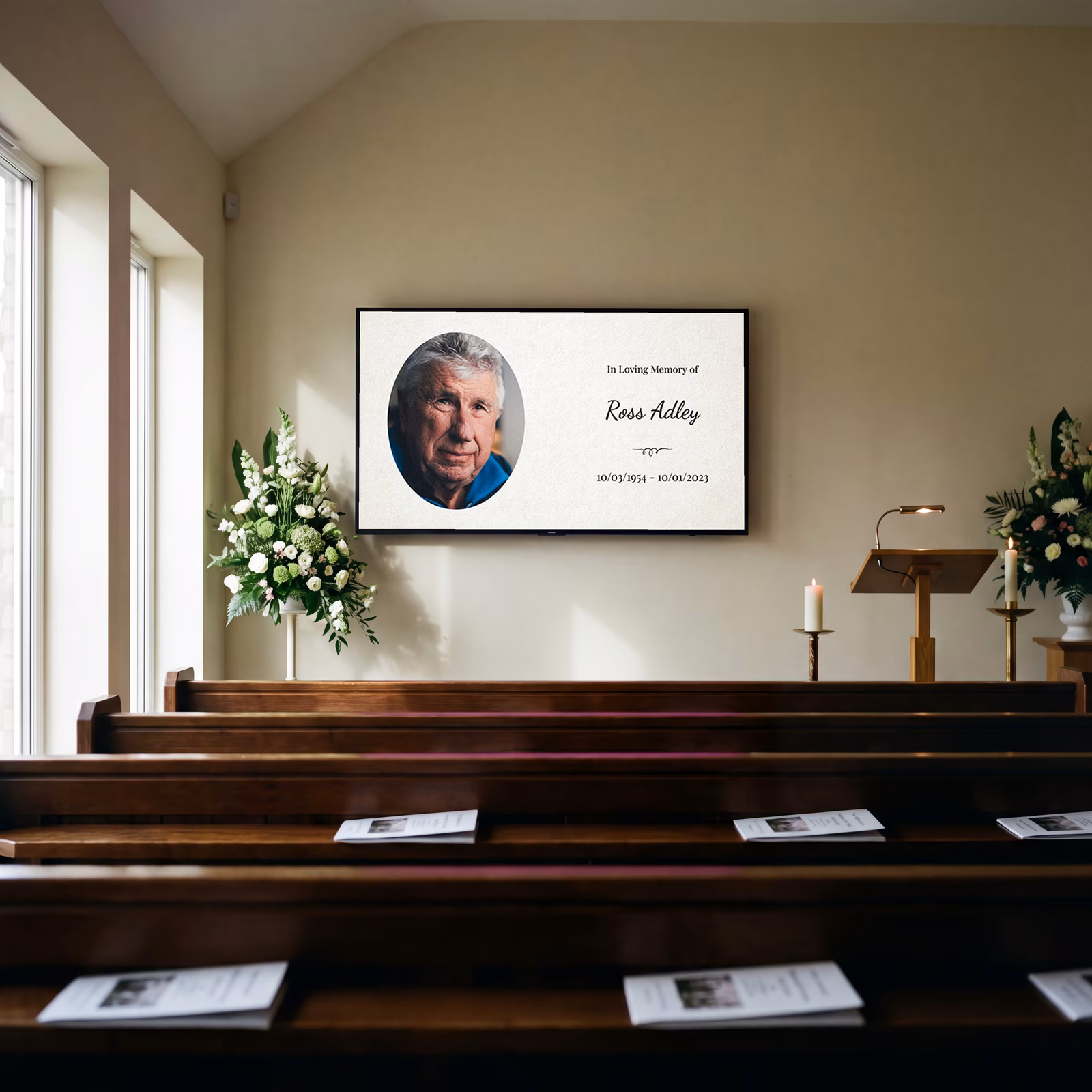 A funeral slideshow title slide with a man's portrait on a screen at the front of a chapel, above pews and white flowers.
