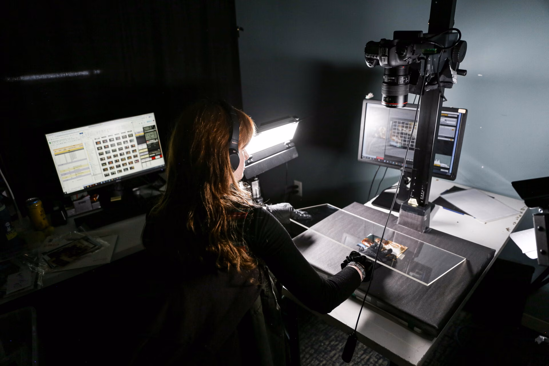 EverPresent technician digitizing a printed photograph using a camera rig and image-processing software.