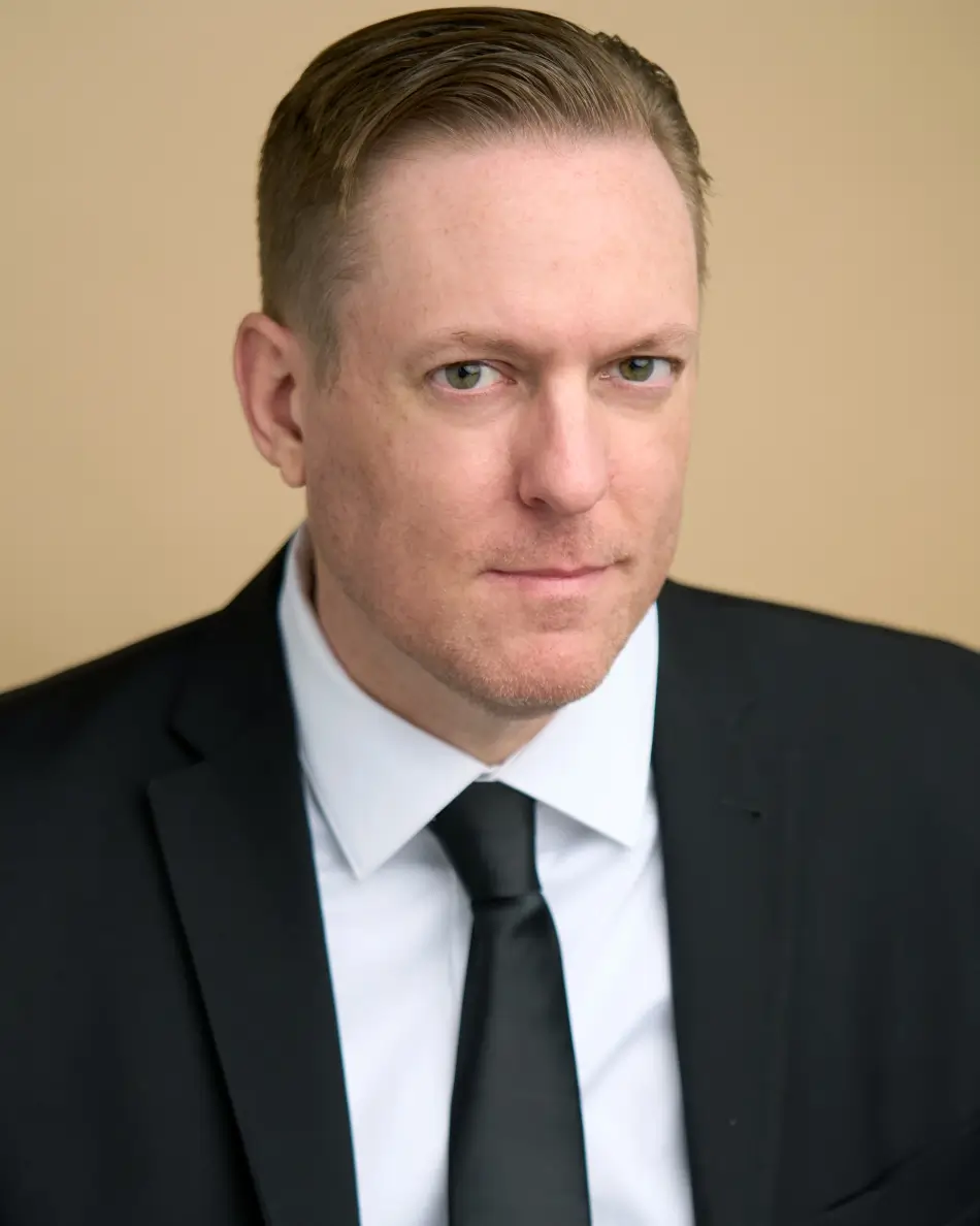 Atlanta men’s actor headshot — male actor in black suit and tie with serious confident expression, FBI agent or law enforcement professional type look.
