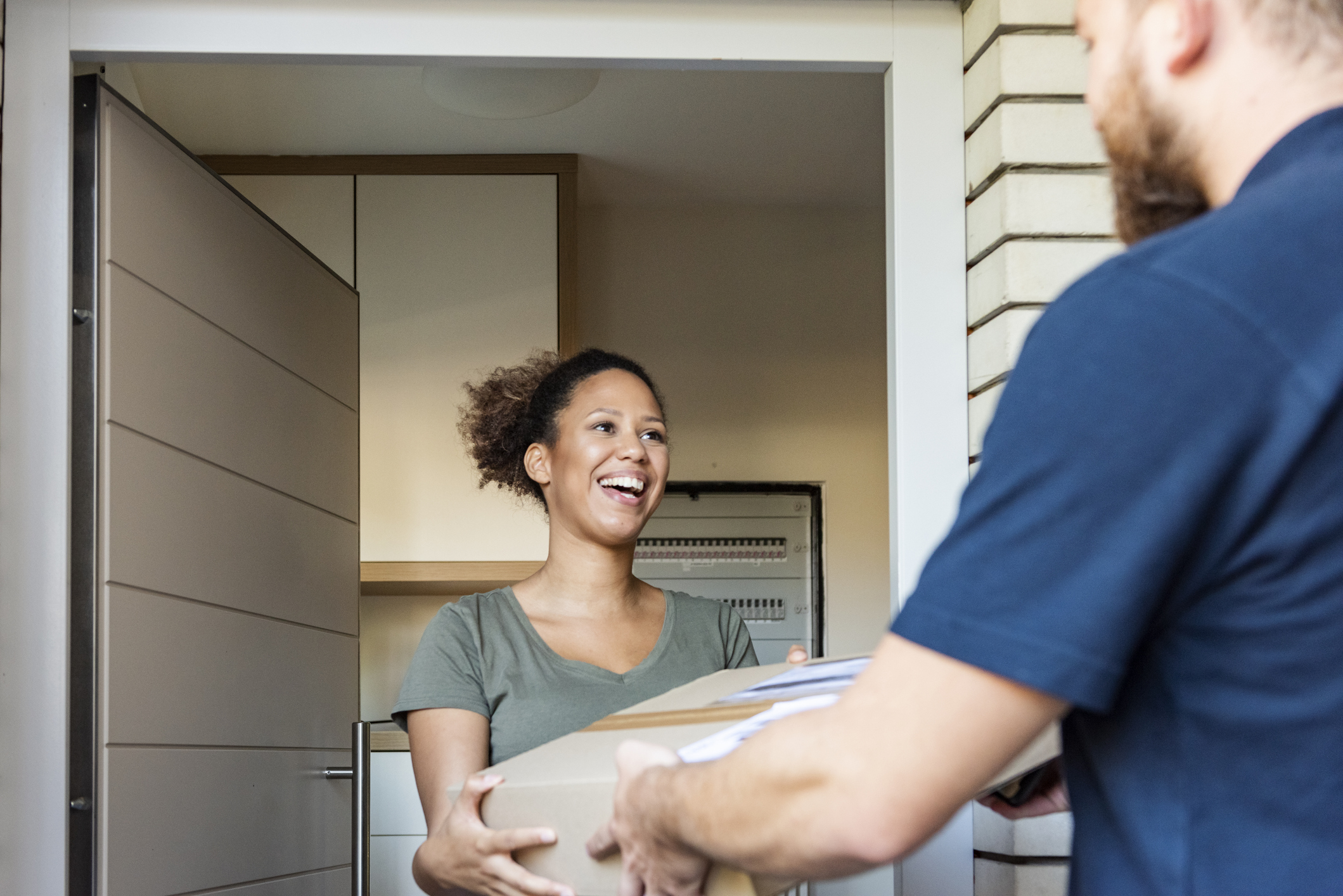 A happy customer receiving their online delivery at the door